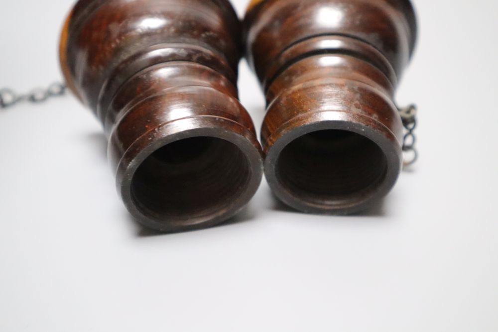 A group of 19th century lignum vitae objects: A pair of whistles and holsters, a match holder with go-to-bed, a model barrel, 9cm, a ga
